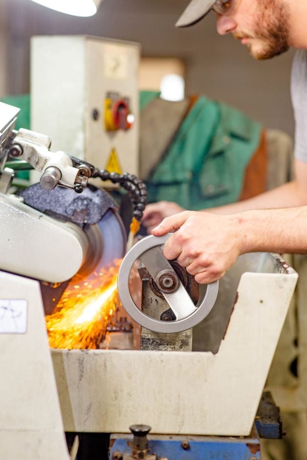 Williams & Hussey employee grinding profile knives